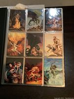 Trading cards with fantasy themed artwork inside nine-pocket page in black Ultra Pro binder.