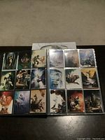 Two pages of trading cards set in plastic sleeves inside a binder, showing detailed fantasy artwork by Hildebrandt and Boris Vallejo.