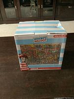 Box of Where's Waldo 3000 piece puzzle unopened showing front and top sides with branding and puzzle image.