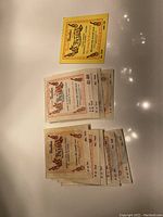 Multiple Bella brand acoustic guitar string sets in original packaging on a reflective surface.