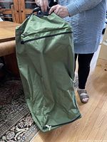 Full view of the green Broadstone wheeled duffel bag, held upright to show shape and material.