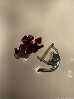Metal capo and cluster of assorted guitar picks on plain surface