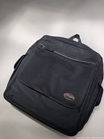 Front view of black Lowepro sling bag showing front zippered compartment and logo