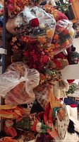 Photo showing bags of artificial autumn floral arrangements and various decorative items including pumpkins and gourds.