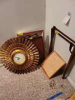 Clock, trays, and luggage stand arranged on carpet near wall showing condition and scale
