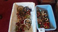 Two baskets filled with various pieces of assorted costume jewelry including bangles, bracelets, earrings, pins, and cufflinks