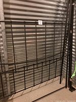 Close-up of queen metal bed frame headboard showing vertical and horizontal bars