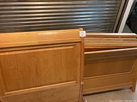 Photo of the wooden twin extra long headboard and footboard with natural light wood grain and paneled design, showing condition and style.