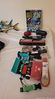 Overview of assorted cycling items on a white surface including pump, mirrors, first aid kit, book and lock cable.