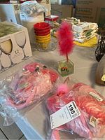 Two pink flamingo stuffed animals in plastic, pink flamingo pen with feather and clear cubic pen holder, small flamingo keychain.