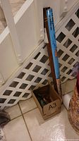 Photo of box on floor containing rolled map of the Caribbean with labeled packaging blue cardboard tube and some miscellaneous small items.