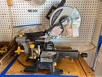 Side view of the 10" Chicago Electric compound slide miter saw showing the base, sliding rails, and adjustment handles and knobs.