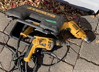 Three used DeWalt corded power tools with black carrying case and cords visible, showing general condition and lot contents