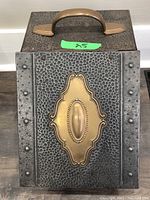 Front view showing hammered steel finish with decorative brass plate