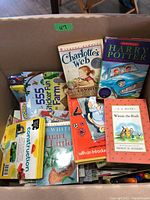 Box containing various children's books including Charlotte's Web, Harry Potter, Stuart Little, Winnie the Pooh, and a construction activity book.