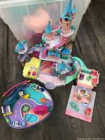 Top view of large fairy-tale castle and two small playsets showing interior stickers and molded details