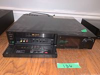 Front view of Sony Stereo VHS video cassette recorder with Swing Shuttle control panel open showing control buttons, knobs, and input jacks.