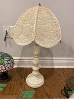 Full view of the wooden table lamp with cane shade showing the overall design and height.