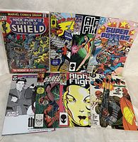 Photo of the full lot of assorted comic books from Marvel, DC, and Scout Comics showing front covers including Nick Fury Agents of SHIELD, The Flash, Alpha Flight and Super Powers.