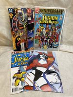 Five comic books displayed in a fan shape, showcasing a variety of titles and genres including Legion of Super Heroes and Marvel.