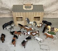 View of the wooden stable with all 16 horse figurines arranged in front.