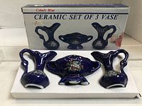 Set of 3 cobalt blue ceramic vases displayed in original packaging box labeled "CERAMIC SET OF 3 VASE."