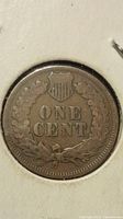 Close-up photo of the reverse side of the 1900 Indian Head penny showing 'ONE CENT' surrounded by a wreath and shield.