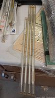 Four glass laboratory thermometers laid out on a table, showing their full length for size comparison.