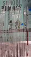 Multiple glass measuring stir sticks displayed on a surface with detailed volume gradations in mL visible, showing variations in length and markings.