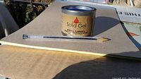 Close-up of single FirePoint solid gel fuel can with pen for size comparison.