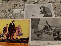 Photo of three Disney movie stills and lobby cards on a granite surface.