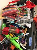 Top view showing cloth tablecloths and a pile of assorted kitchen gadgets including wooden spoons, cutters, and utensils