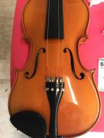 Close-up image of violin body showing fine tuners on tailpiece and chinrest.