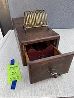 Full view of vintage wooden card file box with brass spiral coil holder on top, drawer open to show front and compartment interior.