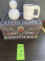 Christmas-themed large box with holiday decorations holding snowman figurine and mug