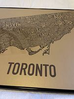 Close-up of Toronto neighbourhood map with neighbourhood names in gold/black.