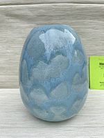 Front angle showing the blue glazed ceramic vase with cloud-like texture.