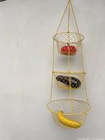 Front view of the full hanging basket with glass fruit inside each tier