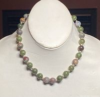 Front view of the 15-inch necklace showing multicolored jade beads separated by 925 silver spacer beads on a white mannequin bust.