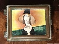Top view of copper trinket box lid showing enamel painting of a woman with hat, signature 'Modigliani'