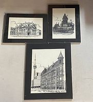 Three framed Toronto cityscape prints hung on wall, showing detailed black and white architecture drawings