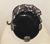 Front view of sterling silver panther brooch pendant with black onyx center and marcasite accents