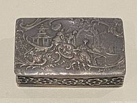 Top view of sterling silver pill box with Chinese repousse scene showing pagoda and figures