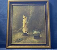 Framed print showing the artwork depicting a white statue figure and an ornate jar, set on a textured surface with peacock feather and subtle background pattern.