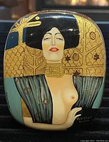 Top view of the oval lacquered trinket box featuring detailed hand-painted Gustav Klimt-inspired woman design with gold, black, and blue elements.