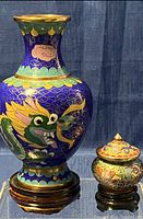 Photo showing full front and side view of the blue enamel cloisonné vase with dragon design and wooden base along with miniature trinket box.