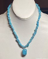 Front view showing the full length of the turquoise nugget beaded necklace and prominent rectangular pendant bead.