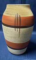 Full front view of pottery vase showing color bands and brush stroke decoration.