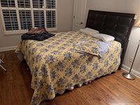 Full view of assembled bed frame with yellow floral reversible quilt and pillow arrangement