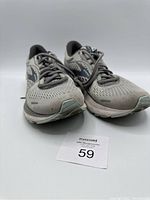 Front angle showing toe and upper mesh of both gray Brooks Adrenaline 21 shoes size 10, some dirt visible.